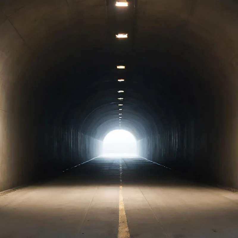 Dunkler Tunnel mit Licht am Ende visualisiert das sogenannte Tunnelhören im Stresszustand. Verweist auf zentrale Keywords wie „Tunnelhören“, „Stress und Hörwahrnehmung“ und „veränderte Geräuschfilterung“.